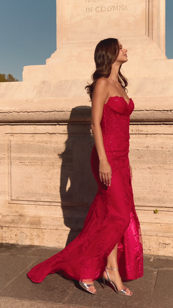 Model wearing Sherri Hill 57935 strapless fitted gown with corset bodice, lace detailing, and high slit.  This is a video.