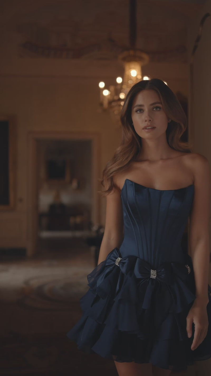 Model wearing Sherri Hill 57276 strapless satin cocktail dress with bow accents on waist and chiffon ruffle skirt.  This is a video.
