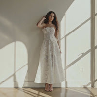 Model wearing the Helsi Sophie DR6474 strapless dress featuring 3D floral appliqués and a high-low silhouette.