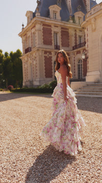 Model wearing Sherri Hill 57693 strapless floral gown with ruffle-layered skirt and slit, posing outdoors in elegant sunlight.  This is a video.