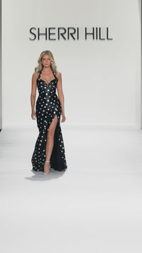 Model wearing the Sherri Hill 57802 halter neckline fitted gown with a high slit.  This is a video.