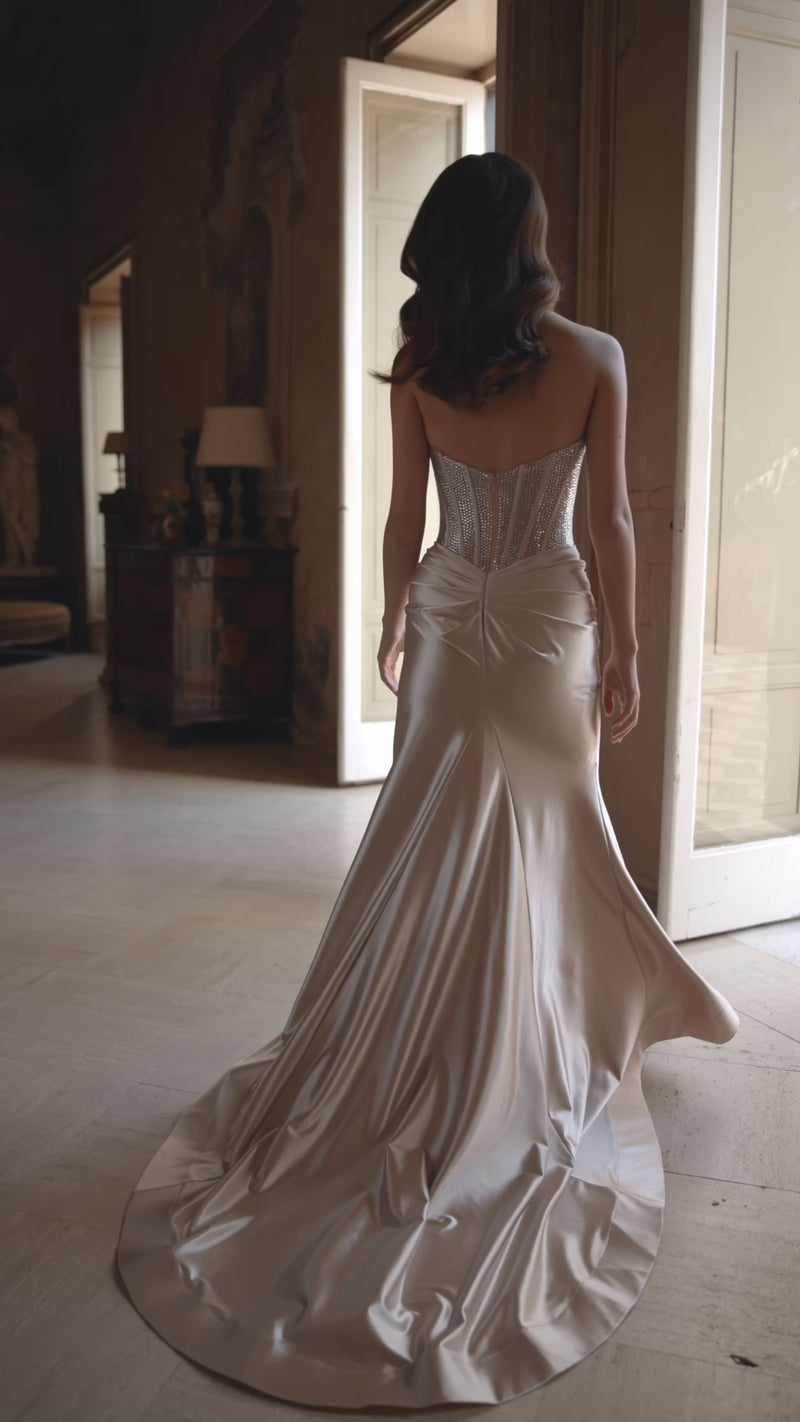 Model wearing Sherri Hill 57473 strapless fitted gown with sparkling hot fix corset and high-slit skirt. This is a video.