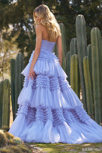 A stunning strapless tulle ball gown with a ruffle skirt and a stylish slit, perfect for prom and quinceañera celebrations. Available at Madeline's Boutique in Toronto and Boca Raton.