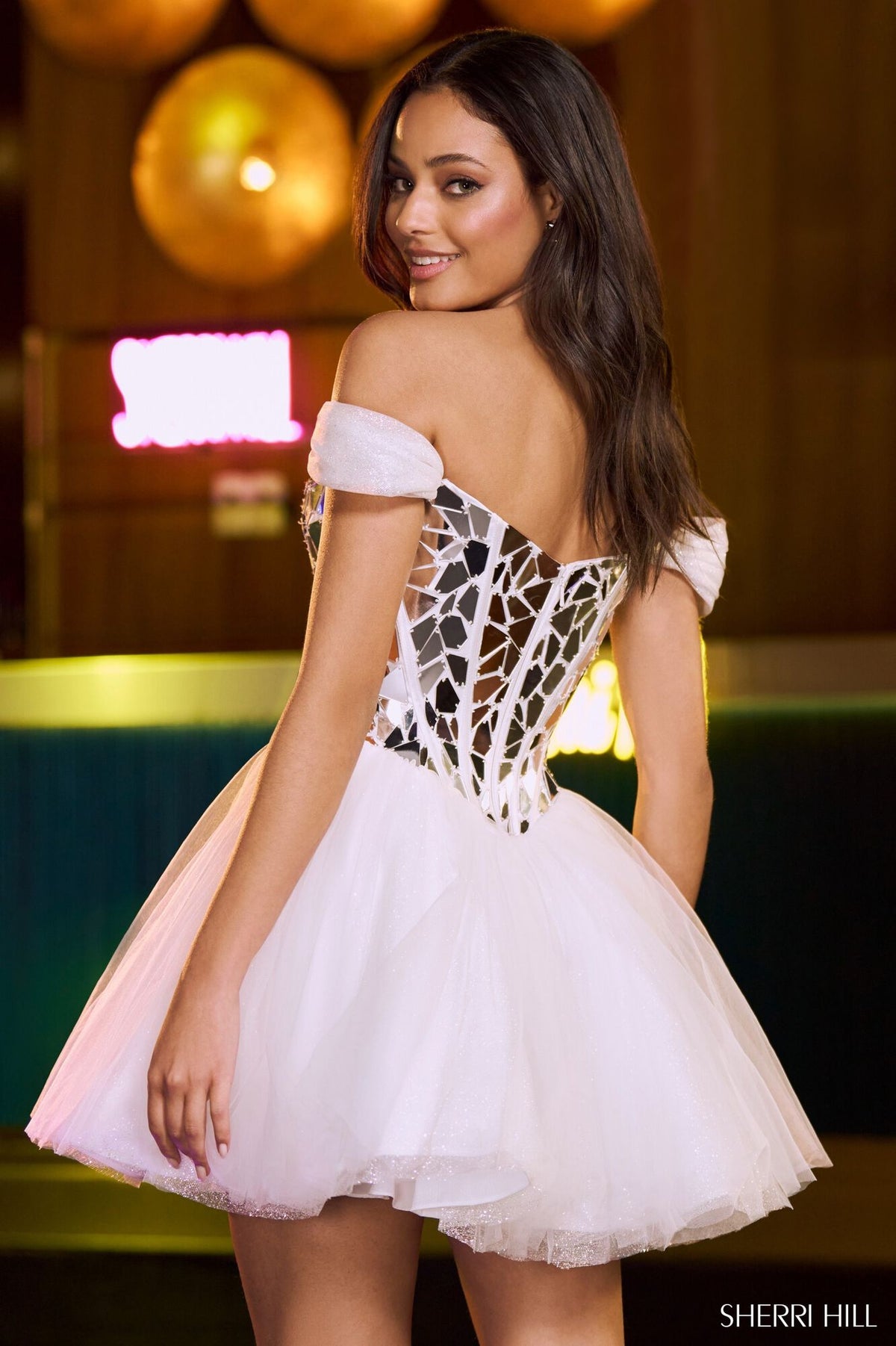 Embrace glamour with Sherri Hill's 55715 dress featuring a cut glass embellished bodice, glittery tulle skirt, and off-the-shoulder sleeves. Perfect for homecoming and graduation. Available at Madeline's Boutique in Toronto and Boca Raton, Florida.