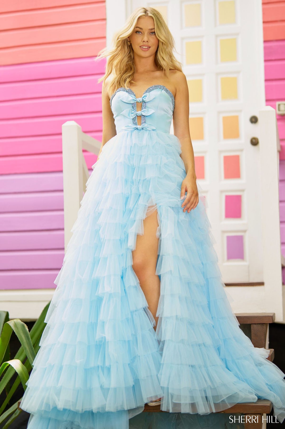 Sherri Hill 56012 Strapless A-line Prom and Quinceañera Gown - An enchanting gown featuring a strapless A-line silhouette, deep V neckline, bow embellishments, and a ruffle skirt with a slit for an elegant and timeless look.