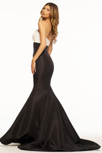 A mesmerizing strapless taffeta mermaid prom gown with a ruched neckline, keyhole, and intricate flower detail on the bodice. Perfect for prom or evening events.