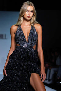 Model wearing a black sequin dress on a runway