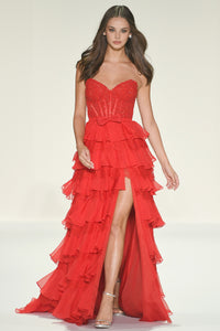 Red tiered dress with a high slit worn by a model on a white background