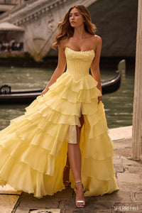 Model wearing Sherri Hill 57541 strapless corset ballgown with cascading chiffon ruffle skirt and slit.