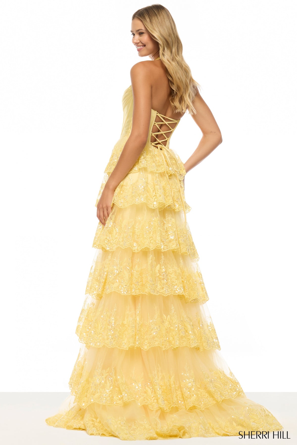 Yellow tiered dress with lace-up back on a white background, Sherry Hill brand visible.