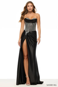 Model wearing Sherri Hill 57634 strapless fitted gown with embellished corset bodice and high slit skirt.