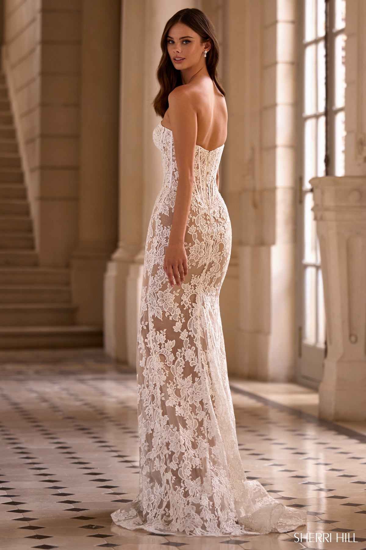 Woman wearing a white lace gown in an elegant interior setting
