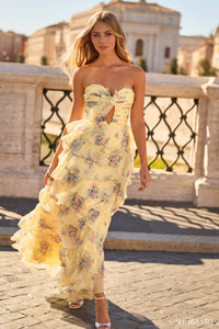 Woman in a yellow floral dress walking outdoors with classical architecture in the background