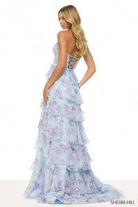 Woman wearing a floral tiered dress with 'Sherri Hill' branding on a white background