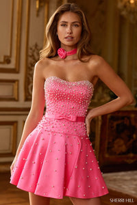 Woman wearing a pink dress with embellishments in an elegant interior setting