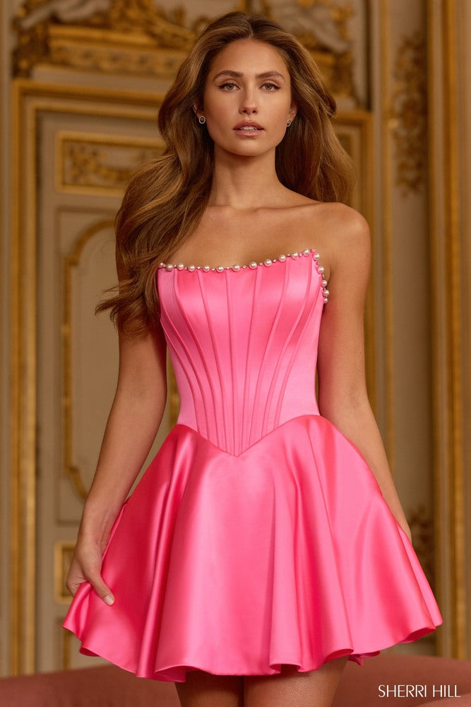 Woman wearing a candypink strapless dress with a decorative neckline in an ornate room.