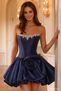 Model wearing Sherri Hill 58154 strapless cocktail dress with a beaded neckline, corset bodice, rose embellishment, bubble hem, and lace-up back.
