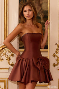 Woman wearing a strapless chocolate brown dress with a bow detail in an ornate room.
