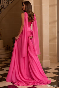 Woman wearing a pink evening gown with a sheer overlay in an elegant interior setting.