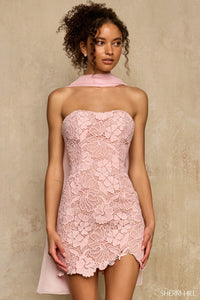 Model wearing a pink lace dress against a beige background
