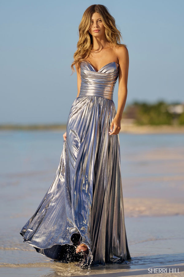 Sherri Hill 56065 Pleated Metallic Strapless Gown with ruched bodice and skirt slit.  The model is wearing the dress in the color silver.