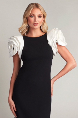 A woman wearing a knee-length cocktail sheath dress with contrast rosette shoulders, perfect for elegant evening occasions.