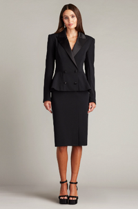 A woman wearing a long-sleeved textured crepe evening dress with a tuxedo collar, perfect for elegant evening occasions.