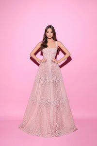 Woman wearing a pink evening gown against a pink background