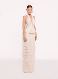 Model wearing the Tarik Ediz 98819 halter plunge neckline column gown with tiered skirt detailing, open back, floral accent, and long sash.