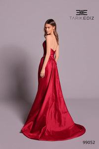 Red evening gown on a model with 'Tarik Ediz' branding on a gray background