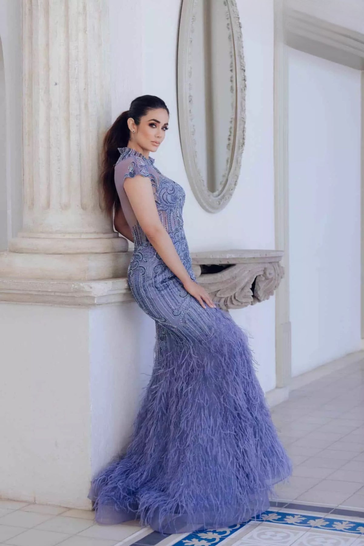 Turn heads in Terani Couture's feathered mermaid dress, featuring a high neck and intricate bead embellishments. Perfect for special evening events. Available at Madeline's Boutique in Toronto and Boca Raton, Florida.