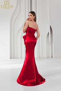 Model wearing Terani Couture 251E4231 one-shoulder gown with ruffle detail and floor-length silhouette. in color ruby.  Back View.
