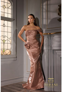 Model wearing Terani 252E5162 off-shoulder gown with draped bodice, rosette detail at hip, and fit-and-flare silhouette.  Model is wearing the color champagne.