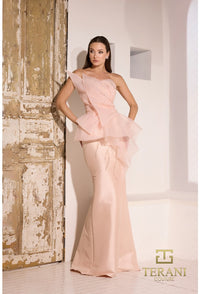 Model wearing Terani Couture 252E5550 strapless gown with peplum detail and mermaid silhouette on the beach.  Model is wearing the dress in the color blush.