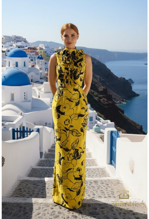 Woman in a yellow floral dress standing on a scenic staircase with a view of the ocean and blue domed buildings.