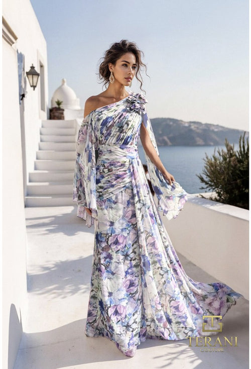Woman in a floral one-shoulder dress standing on a white staircase with a scenic background.