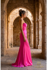 Woman in a magenta dress standing in stone archways