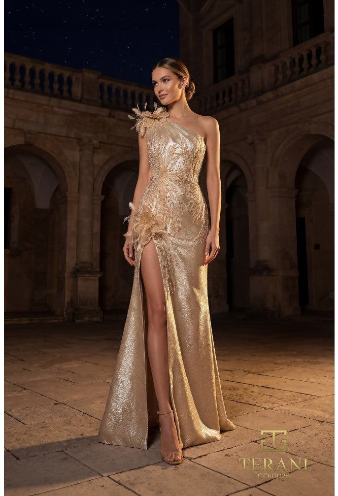 Model wearing Terani 262E7062 one-shoulder evening gown with embellished appliqués, floral accents, high slit, and a fitted floor-length silhouette.
