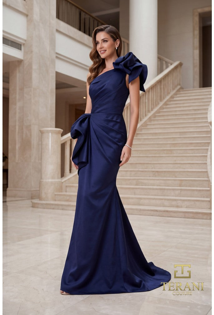 Model wearing Terani 262E7132 one-shoulder mermaid gown in the color navy with draped bodice, statement bow accents, fitted silhouette, and sweep train.