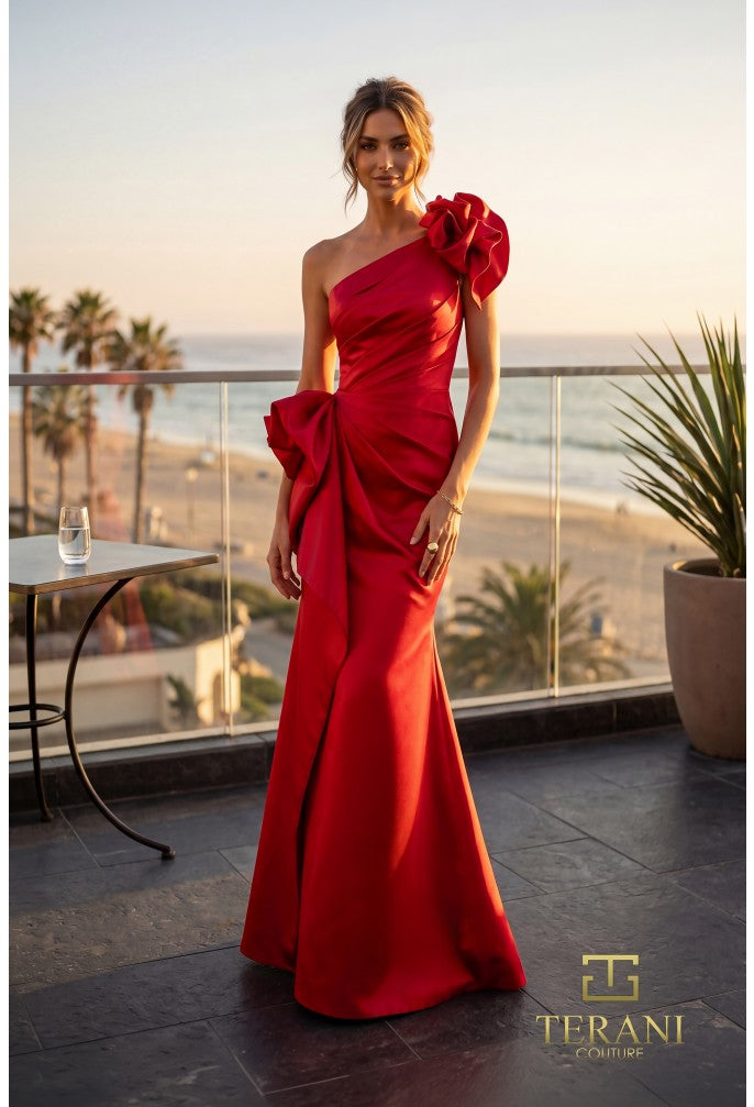 Model wearing Terani 262E7132 one-shoulder mermaid gown in the color red with draped bodice, statement bow accents, fitted silhouette, and sweep train.