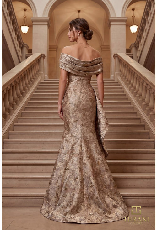 Woman in a gold evening gown standing on a staircase with 'Terani' branding.