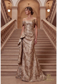 Woman in a gold evening gown standing on a staircase in an elegant building
