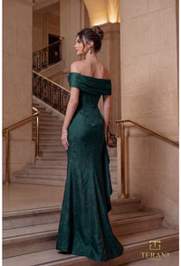 Woman in a evergreen evening gown standing on a staircase with 'Terani' branding.