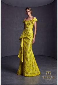 Woman wearing a lemon yellow evening gown with floral details against a gray background, Terani Couture branding visible.
