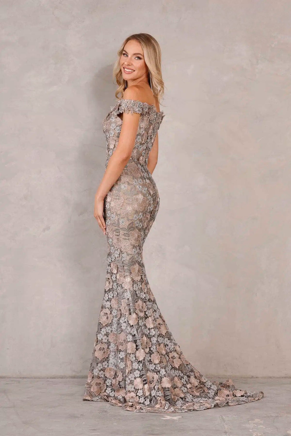 Shop the stunning Terani Couture 2111M5271 long dress at Madeline's Boutique. This pewter bronze lace gown features an off-shoulder design, sweetheart neckline, and a beautiful train. Perfect for evening occasions and as a Mother of the Bride or Groom dress. Visit our Toronto and Boca Raton locations for the latest fashion trends