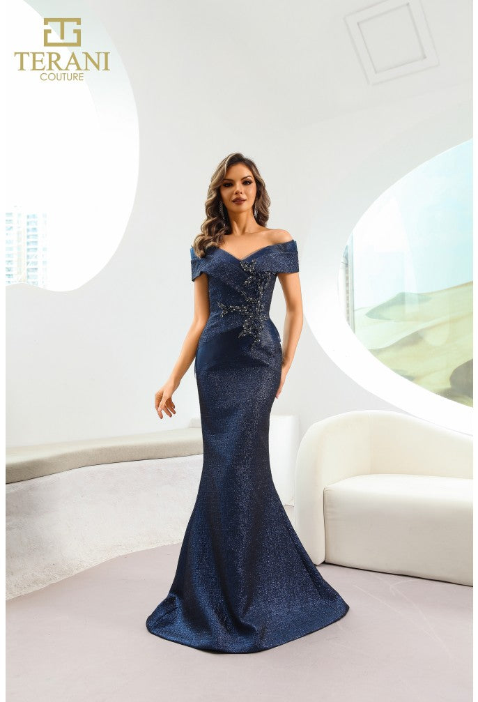 Model wearing Terani Couture 241M2771 off-the-shoulder beaded trumpet gown with fitted bodice and elegant flared skirt in navy front view.