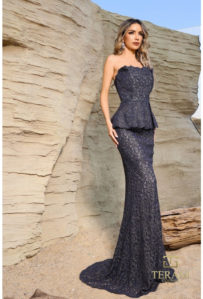 Woman in a strapless, sparkly evening gown standing against a rocky background