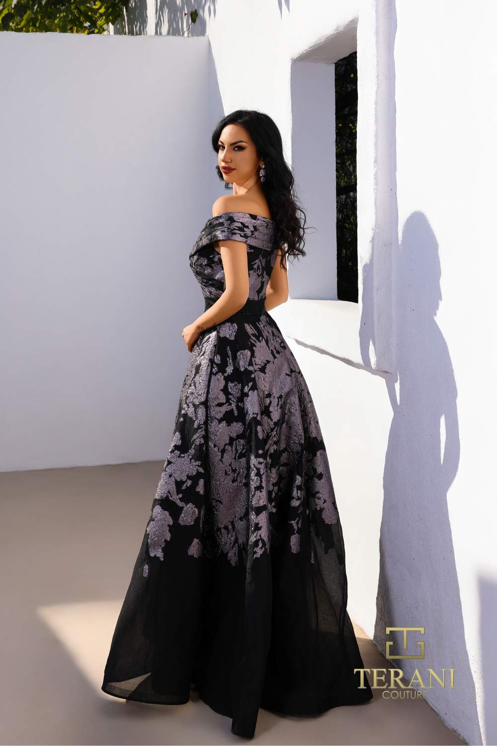 Model wearing Terani Couture 252E5188 off-shoulder A-line evening gown with floral detailing and elegant silhouette.