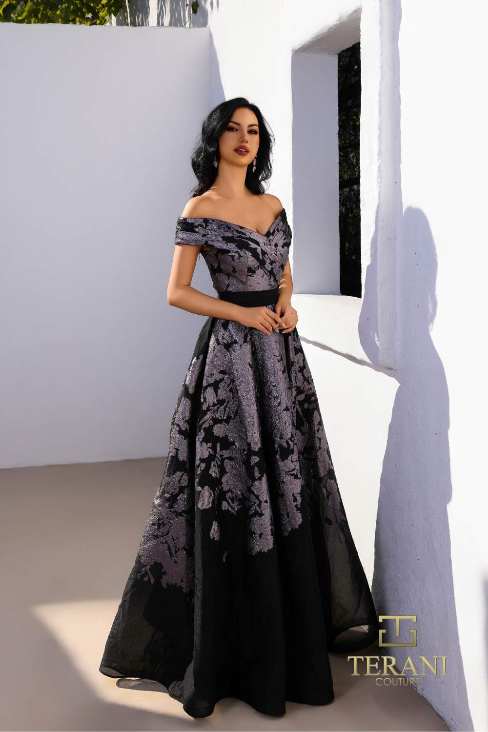 Model wearing Terani Couture 252E5188 off-shoulder A-line evening gown with floral detailing and elegant silhouette.