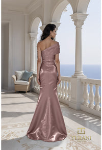 Woman in a espresso evening gown standing on a balcony with a scenic view, Terani brand visible.